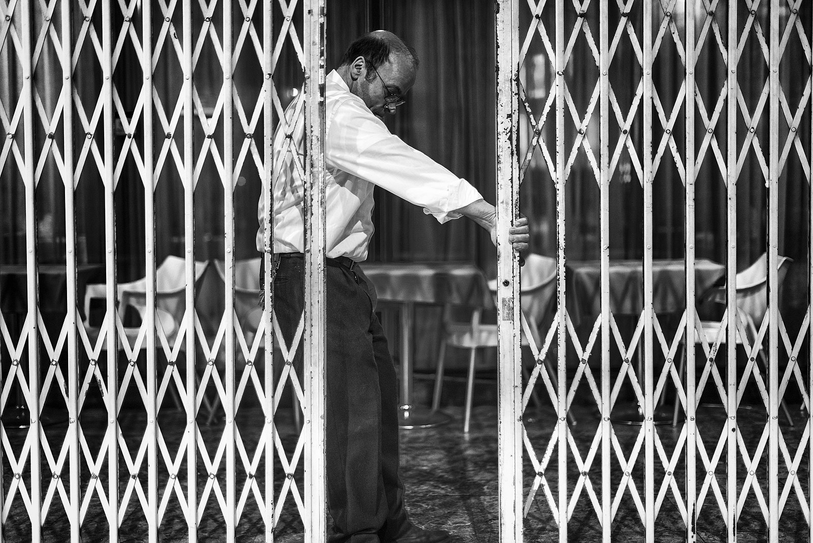 Picture of a shopkeeper closing the shop's shutters